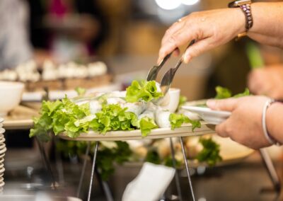 Hand holding tongs and serving themselves a cold roll.