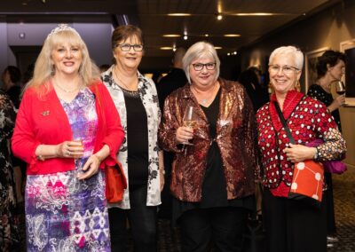 Group of people in formal attire stood smiling.