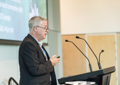 Person stood at a lectern, speaking into microphone.