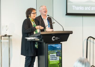 Two people stood at a lectern, speaking into microphone.