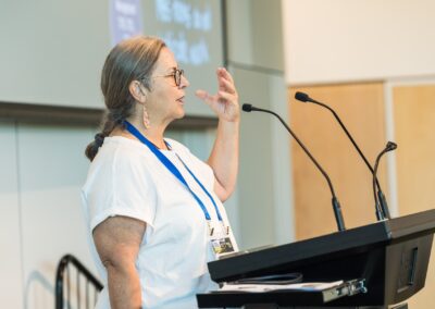Person stood at a lectern, speaking into microphone.
