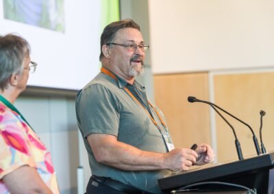 Person stood at a lectern, speaking into microphone.