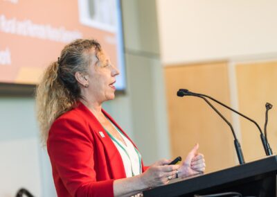 Person stood at a lectern, speaking into microphone.