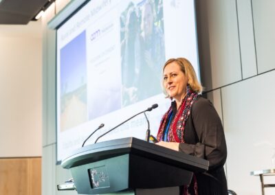 Person stood at a lectern, speaking into microphone.