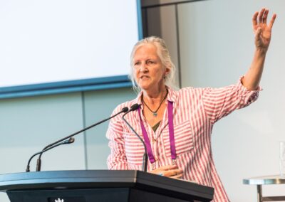 Person stood at a lectern, speaking into microphone.