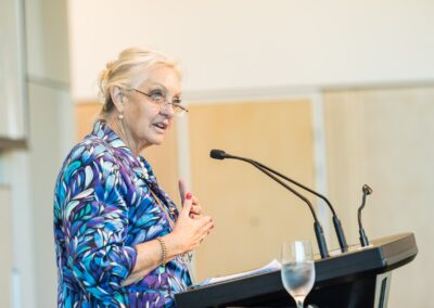 Person stood at a lectern, speaking into microphone.