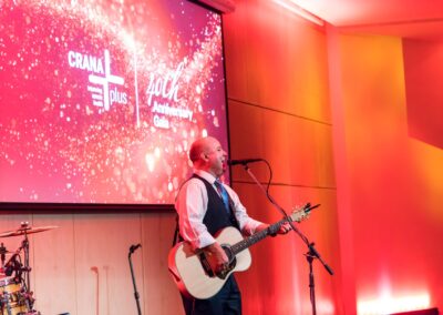 Person playing guitar and singing into microphone on a stand.