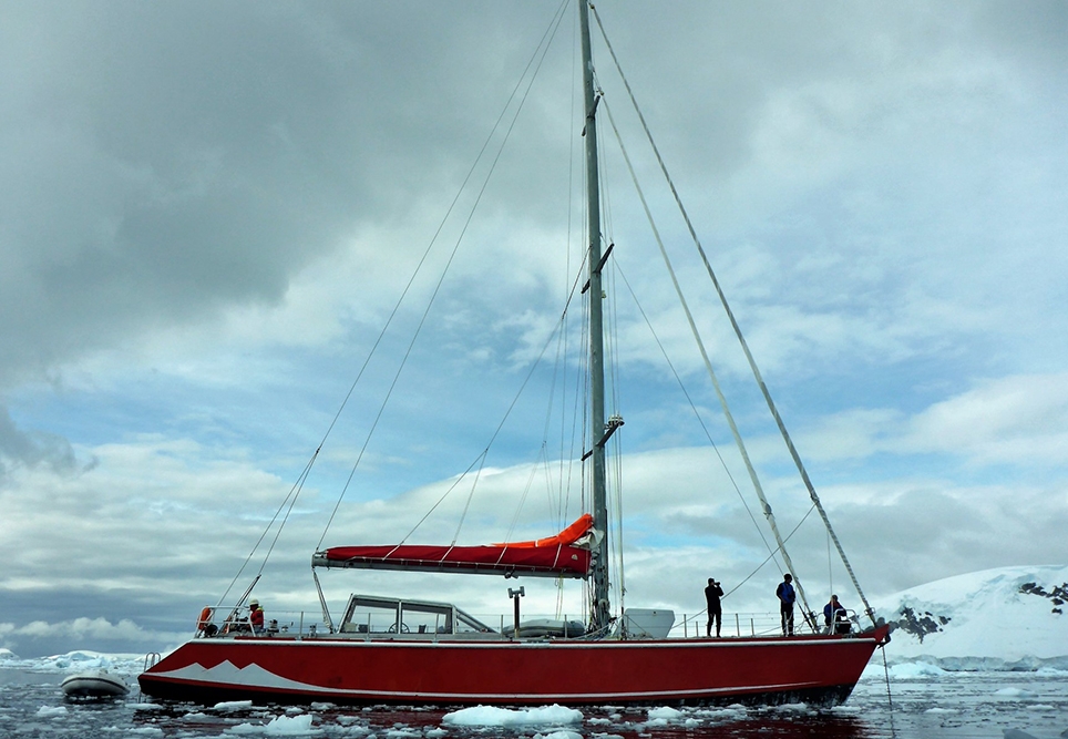 An ice strengthened yacht quietly at anchor on the Antarctic peninsula – the nurse doubles as the cook.